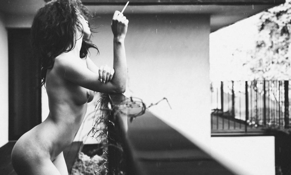 Fille seins nus sur le balcon