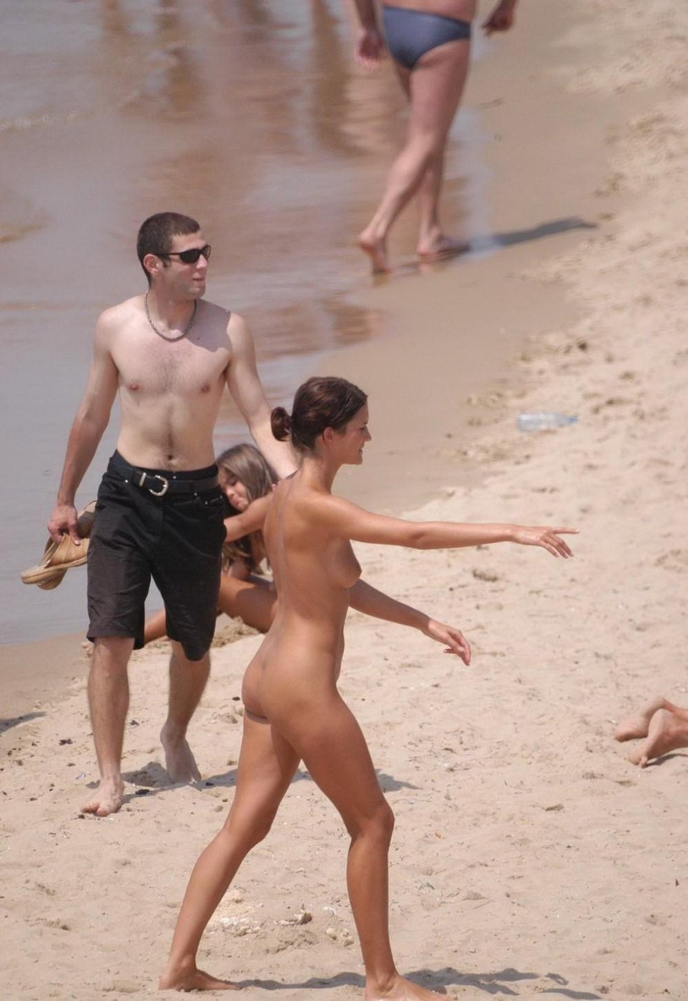 Seins nus sur la plage parmi les habillements