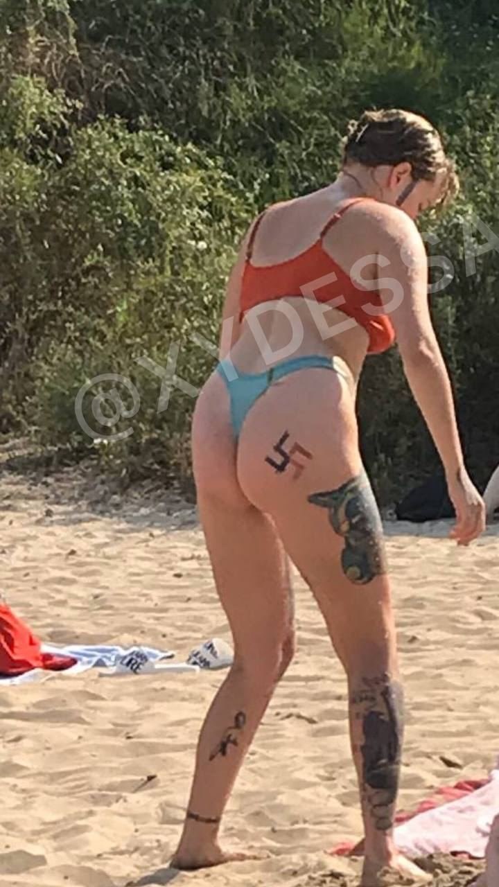 Fille avec du tatouage de croix gammée sur la plage