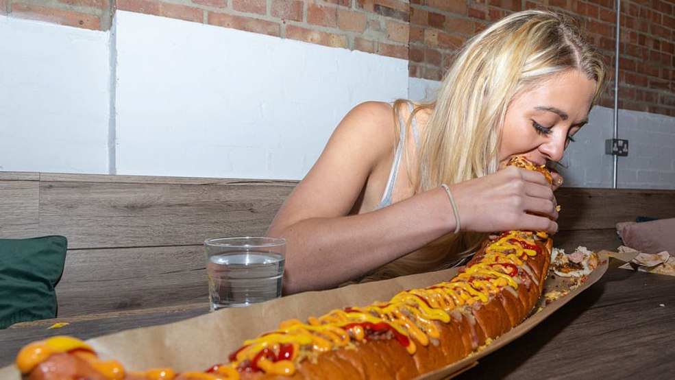 Une fille mange un hot-dog