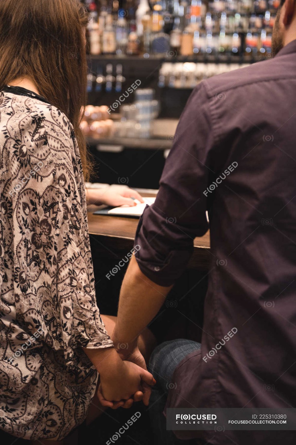 Fille derrière un bar debout de l'arrière