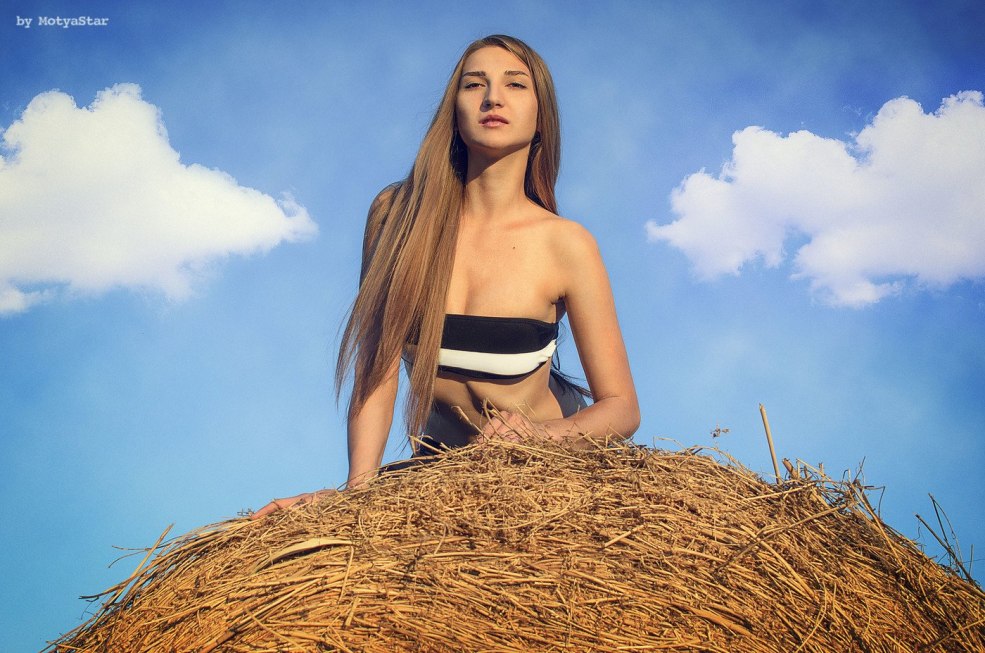 Fille sur le foin dans la robe d'été